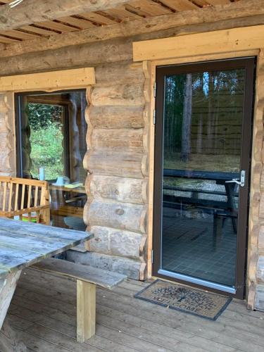 a sliding glass door on a log cabin with a picnic table at Tammeoja puhkemaja in Sõmeru
