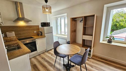 een keuken met een houten tafel en stoelen en een keuken met een aanrecht bij Logements neufs à Bannalec Centre in Bannalec
