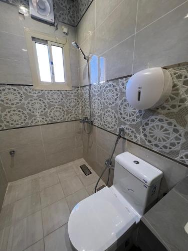 a bathroom with a toilet and a sink and a window at السلطان للشقق المفروشة in AlUla
