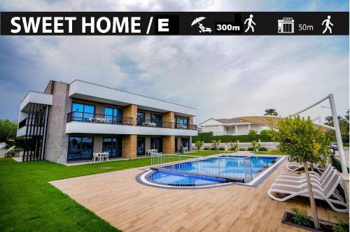 a house with a swimming pool in front of it at Camyuva Beach Hotel in Kemer