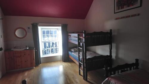 a room with two bunk beds and a window at Fáilte Lodging Kenmare-ROOM ONLY in Kenmare