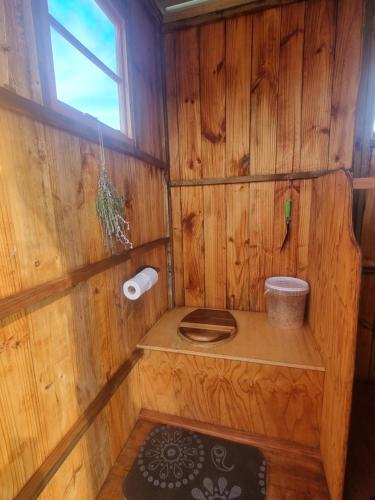 a wooden bathroom with a toilet and a window at Pom Gratz - EcoDomes in Hartebeest Rivier