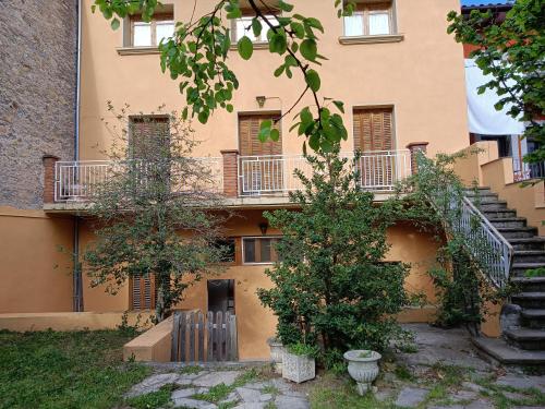 a building with stairs and trees in front of it at El Jardí de Can Prat in Ripoll