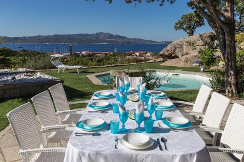 un tavolo con piatti blu e bianchi di Villa Cava Del Tom Luxury a Porto Rotondo
