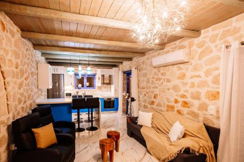 a living room with a couch and a kitchen at Villa Rosemarie - Luxurious Villa with Pool Just Steps Away from the Sea By Villa Mana Gers in Psarou