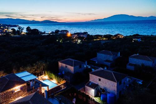 a view of a city and the ocean at night at Villa Rosemarie - Luxurious Villa with Pool Just Steps Away from the Sea By Villa Mana Gers in Psarou
