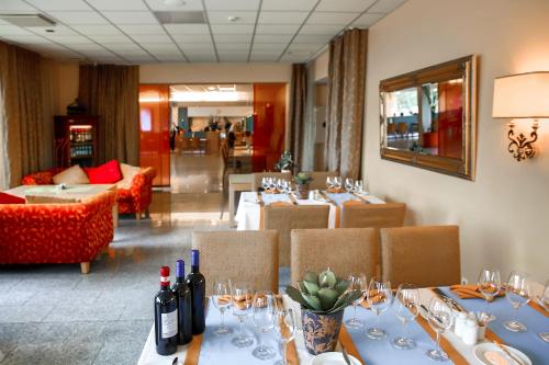 a dining room with tables and chairs with wine bottles at Fra Mare Thalasso Spa in Haapsalu