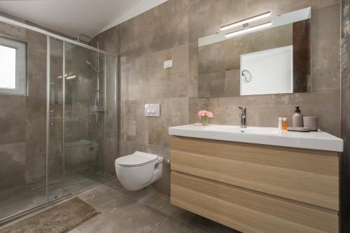 a bathroom with a toilet and a sink and a shower at Apartments Zomzi in Poreč