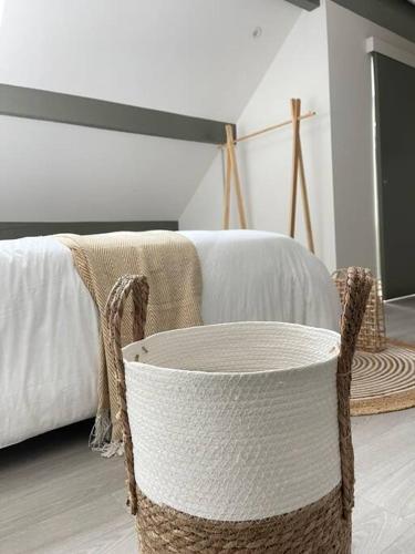 - une chambre avec un lit et un fauteuil en rotin dans l'établissement La Bohème, à Challuy