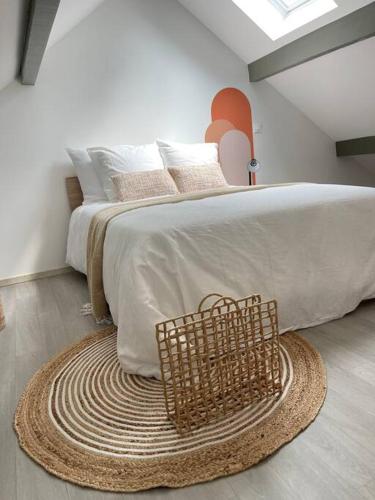 a bedroom with a large bed with a basket on the floor at La Bohème in Challuy