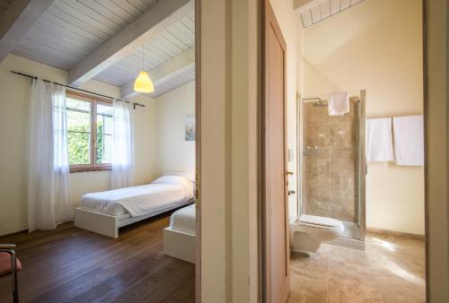 ein Schlafzimmer mit einem Bett und ein Badezimmer mit einer Dusche in der Unterkunft Chalet Rosmarino in Trequanda