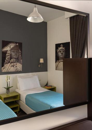 Un reflejo en el espejo de un dormitorio con una cama. en Carafa Suite B&B, en Nápoles