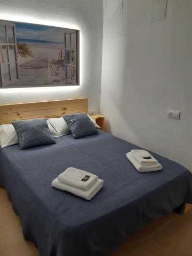 a bedroom with a bed with two towels on it at MIAMI BLAU in Empuriabrava