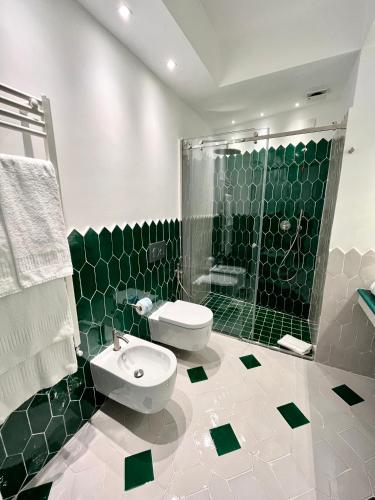 a green and white bathroom with a toilet and a shower at Hotel Il Gabbiano in Positano