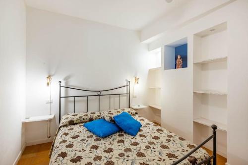 een slaapkamer met een bed met blauwe kussens erop bij La Quercia in Selva di Fasano