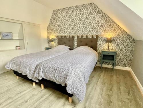 een slaapkamer met een groot bed en 2 tafels bij Sous le Château Bourbon l'Archambault in Bourbon-lʼArchambault
