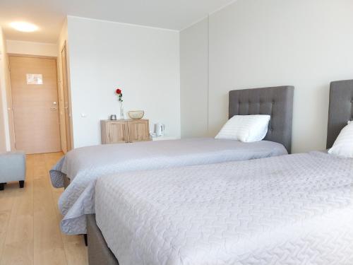 1 dormitorio con 2 camas y mesa con silla en Aisa Apartment, en Pärnu