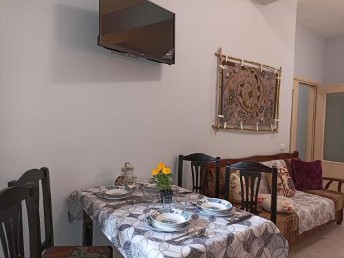 a dining room table with a television on the wall at 10 apartmants Olimpia MIR in Durrës