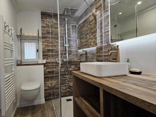 La salle de bains est pourvue d'un lavabo et d'une douche en verre. dans l'établissement Charmant chalet 200 m de la mer, à Merville-Franceville-Plage