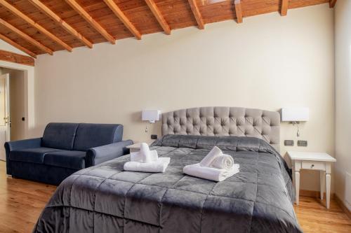 a bedroom with a bed and a blue couch at Villa Romantica Wellness & SPA in Lucca