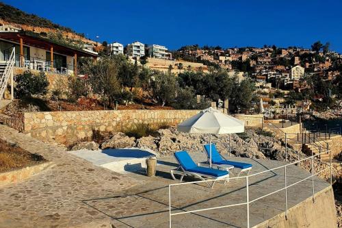 two blue chairs and a white umbrella on a hill at Villa Blue Coast I & II wBeach and Great Sea View - KALKAN in Kas