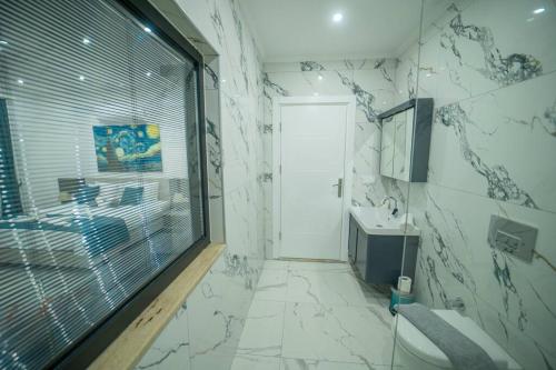 a bathroom with a toilet and a sink and a window at Villa Blue Coast I & II wBeach and Great Sea View - KALKAN in Kas