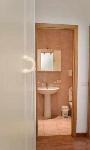 a bathroom with a sink and a mirror and a toilet at Civico 18- La tua casa in centro in Latina