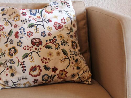 威拉爾－蘇－羅倫的住宿－Apartment Topaze 4 by Interhome，椅子上的枕头和鲜花