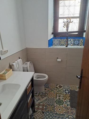 a bathroom with a toilet and a tile floor at Casa de La Parra in Valverde de Júcar