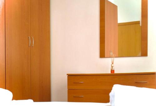 a bedroom with a wooden dresser and a mirror at Civico 18- La tua casa in centro in Latina