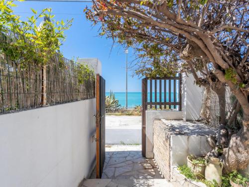an open gate with a tree next to the beach at Studio Seccagrande by Interhome in Borgo Bonsignore