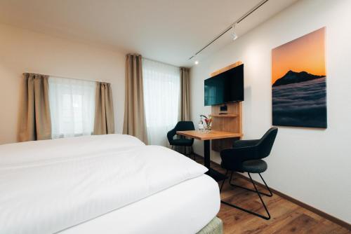 a hotel room with a bed and a table with chairs at Hotel Drei König in Immenstadt im Allgäu