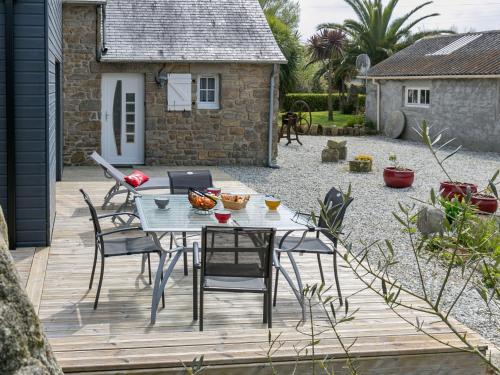 a patio with a table and chairs in a yard at Holiday Home Kernic Ty - PLC219 by Interhome in Plounévez-Lochrist