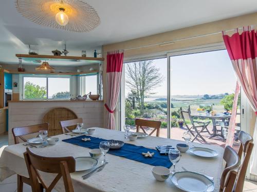 uma sala de jantar com uma mesa e uma grande janela em Holiday Home Villa Panorama Mer by Interhome em Plounéour-Trez