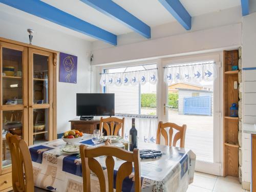 una sala da pranzo con tavolo, sedie e TV di Holiday Home Ty Kerveal - TEC210 by Interhome a Santec