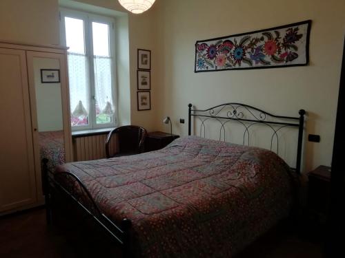 a bedroom with a bed with a red blanket and a window at Villa Brumar in Brebbia