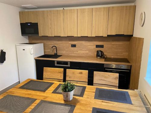 a kitchen with a wooden table with a sink and a stove at Holiday Home Holiday Hill 29 by Interhome in Lauterwasser