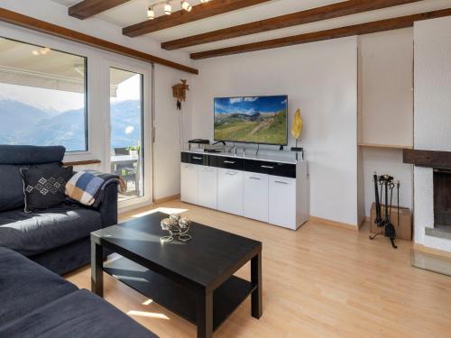 a living room with a couch and a table and a tv at Chalet Le Fontany by Interhome in Randogne