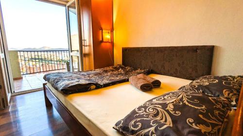sypialnia z 2 łóżkami i dużym oknem w obiekcie Apartment Sea & Mountain w Barze