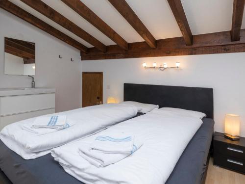 a bedroom with two beds with white sheets at Chalet Maison Le Fontany by Interhome in Randogne
