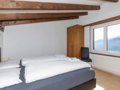 a bedroom with a bed and a window at Chalet Maison Le Fontany by Interhome in Randogne