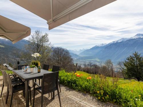 a table and chairs with a view of mountains at Chalet Maison Le Fontany by Interhome in Randogne