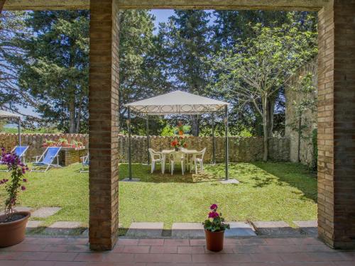 un giardino con tavolo e ombrellone di Apartment Fattoria Petraglia - Loggiato by Interhome a Monteriggioni