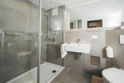 a bathroom with a shower and a sink and a toilet at Hotel Drei König in Immenstadt im Allgäu