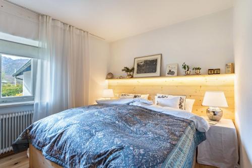 een slaapkamer met een groot bed en een raam bij Haus Alpenveilchen - Appartement 2 in Schönau am Königssee