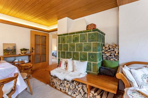 a living room with a fireplace and a table with logs at Haus Alpenveilchen - Appartement 2 in Schönau am Königssee
