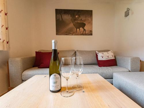 a bottle of wine and two wine glasses on a table at Holiday Home Haus Weickl by Interhome in Kaprun