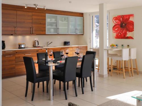 una sala da pranzo con tavolo, sedie e bicchieri da vino di Apartment L'Esplanade A6-14 by Interhome a Montreux