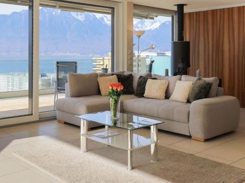 Apartment L'Esplanade A6-14 by Interhome في مونترو: غرفة معيشة مع أريكة وطاولة زجاجية