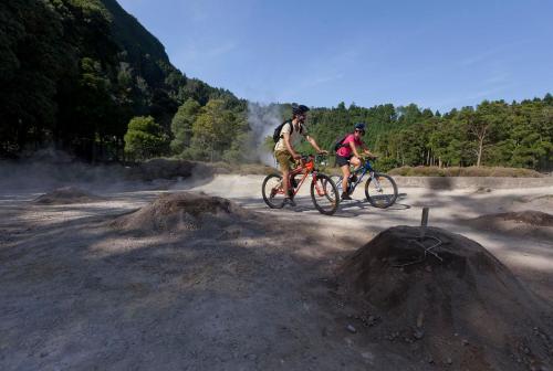 two people riding bikes on a dirt road at B&C Furnas House in Furnas